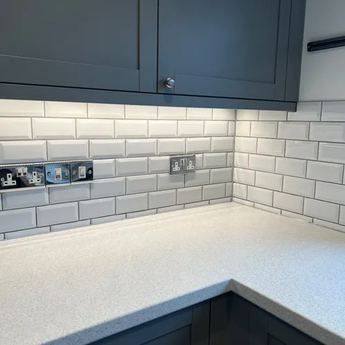Kitchen Renovations: Example 4 close up photo of one of the many kitchen renovations done by Robertson Renovations. Dark blue cabinets, white brick tiles and white worktop.
